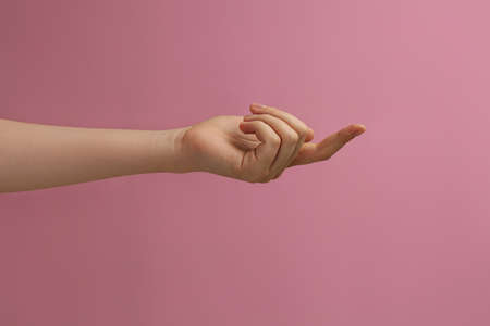 Woman showing index finger on pink background, closeupの写真素材