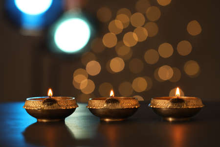 Lit diya lamps on dark table. Diwali celebrationの写真素材