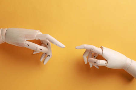 Wooden mannequin hands on orange background, flat layの写真素材