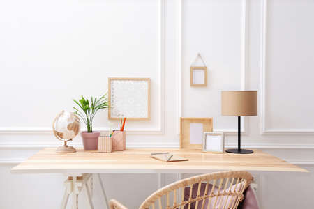 Wooden table with desk lamp in room. Interior designの写真素材