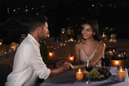 Romantic couple on cafe terrace at nightの写真素材