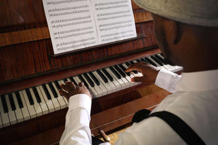 African-American man playing piano, closeup. Talented musician