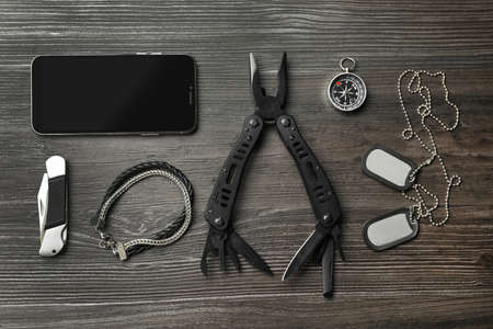 Flat lay composition with compact portable multitool and accessories on wooden tableの写真素材