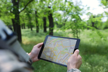 Soldier using tablet in forest, closeup viewの写真素材