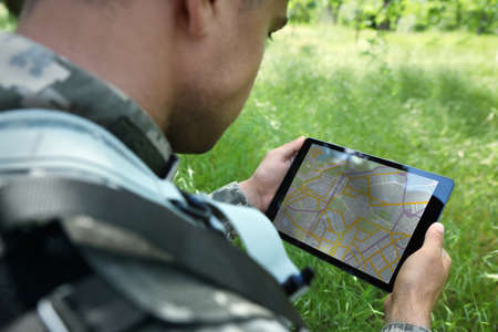 Soldier using tablet in forest, closeup viewの写真素材