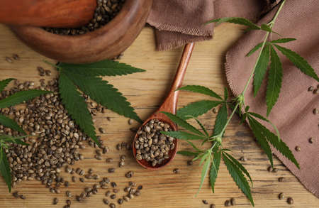 Flat lay composition with hemp seeds and leaves on wooden tableの写真素材