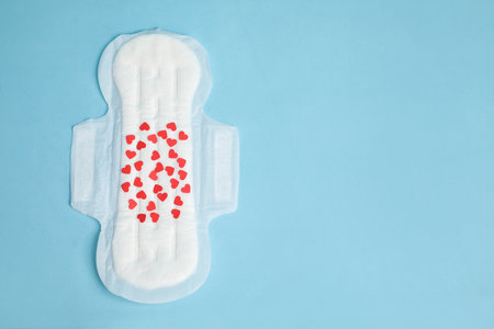 Menstrual pad with confetti on light blue background, top view. Space for textの写真素材