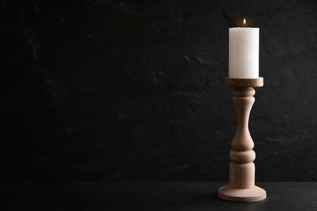 Elegant candlestick with burning candle on black table. Space for textの写真素材