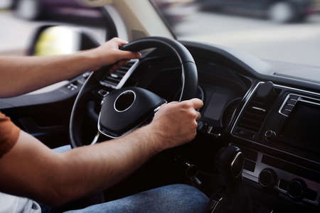 Man driving his car, closeup view of hands on steering wheelの写真素材