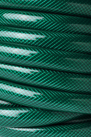 Green rubber watering hose as background, closeupの写真素材
