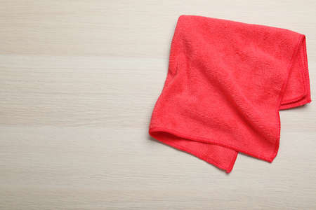 Red microfiber cloth on light wooden background, top view. Space for textの写真素材