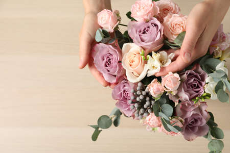 Florist creating beautiful bouquet at table, top view. Space for textの写真素材