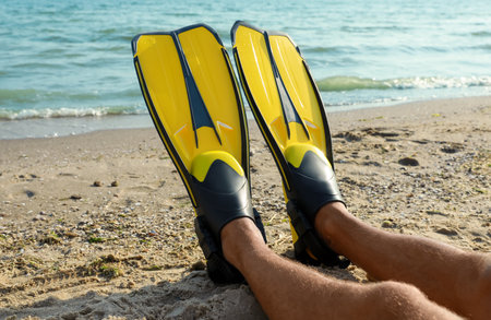 Man in flippers near sea on beach, closeupの写真素材