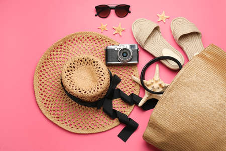Stylish bag with beach accessories on pink background, flat layの写真素材