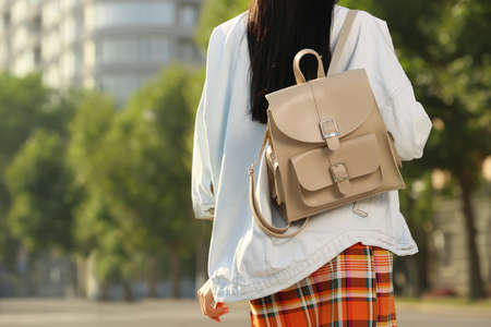 Young woman with stylish beige backpack on city street, closeup. Space for textの写真素材