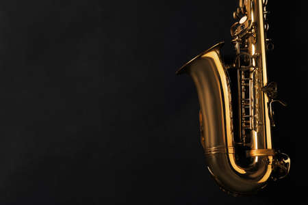 Beautiful saxophone on black background, top view. Space for textの写真素材