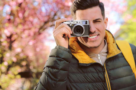 Happy male tourist with camera outdoors on spring dayの写真素材
