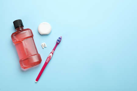 Mouthwash, toothbrush and dental floss on light blue background, flat lay. Space for textの写真素材
