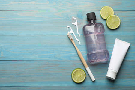 Flat lay composition with mouthwash and other oral hygiene products on turquoise wooden background. Space for textの写真素材