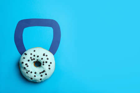 Kettlebell made of tasty donut on light blue background, top view. Space for textの写真素材