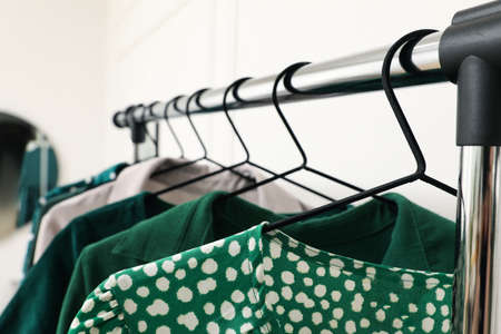 Rack with hanging clothes indoors, closeup. Interior designの写真素材