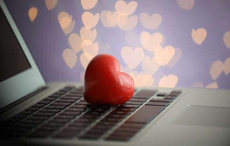 Red decorative heart on laptop, closeup. Online datingの写真素材