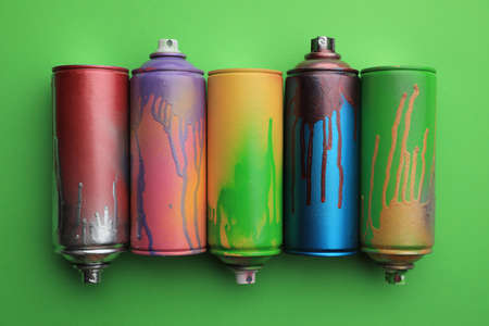 Used cans of spray paints on green background, flat lay. Graffiti suppliesの写真素材