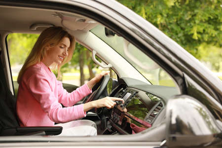 Young woman using navigation system while driving car