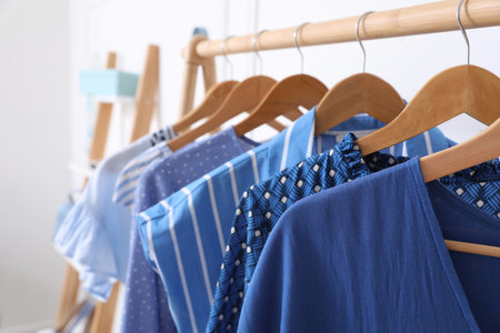 Rack with stylish hanging clothes in dressing roomの写真素材