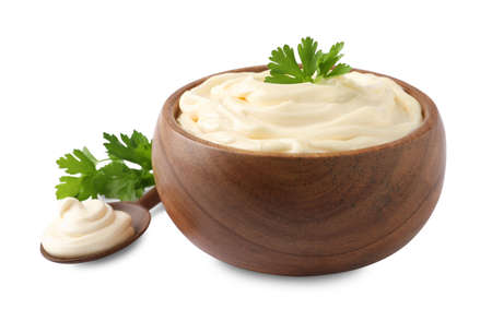 Spoon and bowl of delicious mayonnaise with parsley on white backgroundの写真素材