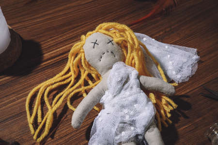 Bride voodoo doll pierced with pins on wooden backgroundの写真素材