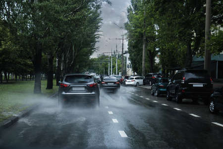 View of city road with cars on rainy dayの写真素材