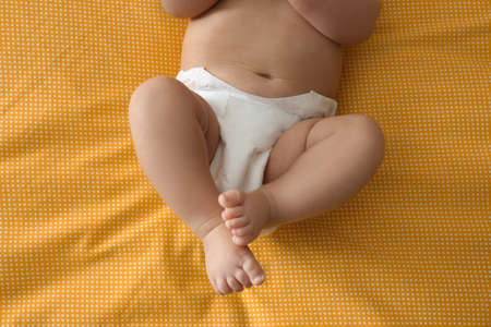 Cute little baby in diaper on yellow blanket, top viewの写真素材