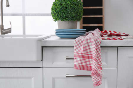 Different towels and stack of plates near sink on kitchen counterの写真素材