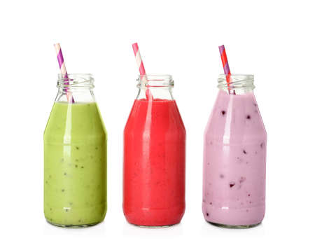 Different smoothies in glass bottles on white backgroundの写真素材