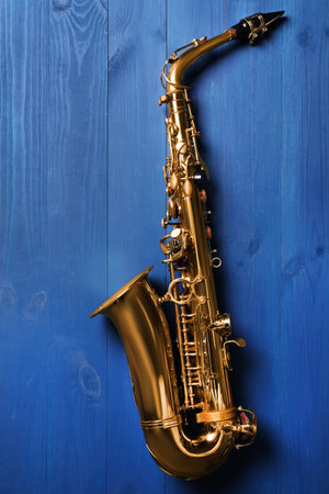 Beautiful saxophone on blue wooden background, top viewの写真素材