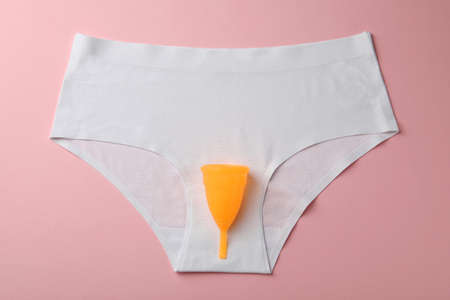 Menstrual cup and panties on pink background, top viewの写真素材