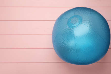Light blue beach ball on pink wooden background, top view. Space for textの写真素材