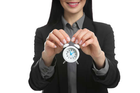 Businesswoman holding alarm clock on white background, closeup. Time managementの写真素材