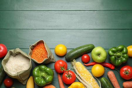 Fresh fruits, vegetables and seeds on green wooden table, flat lay. Space for text