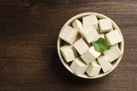 Delicious tofu with parsley on wooden table, top view. Space for textの写真素材
