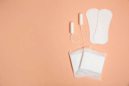 Menstrual pads, tampons and pantyliners on pale orange background, space for textの写真素材