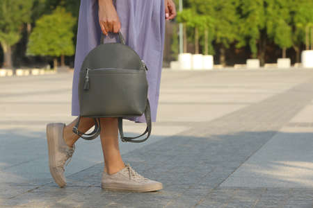 Young woman with stylish backpack on city street, closeup. Space for textの写真素材