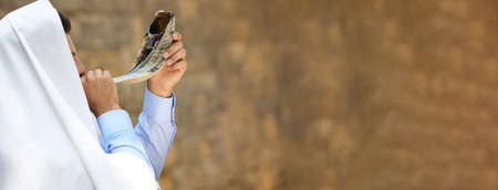 Jewish man in tallit blowing shofar outdoors, banner design. Rosh hashanah celebrationの写真素材