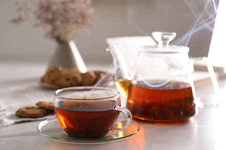 Glass cup of hot tea served for breakfast on white tableの写真素材
