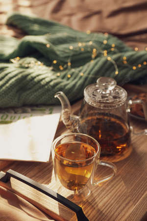 Wooden tray with freshly brewed tea on bed in room. Cozy home atmosphereの写真素材