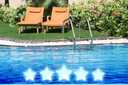 Sunbeds near swimming pool at five star hotelの写真素材