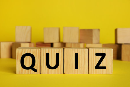 Wooden cubes with word Quiz on yellow background. Space for textの写真素材