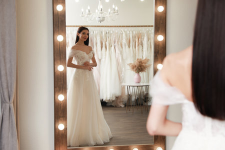 Woman trying on beautiful wedding dress in boutiqueの写真素材