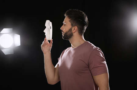 Professional actor rehearsing with mask on stage in theater